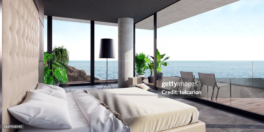 Modern luxurious bedroom with large terrace in a villa by the ocean