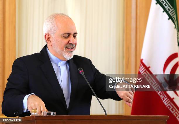 This picture taken on February 13, 2019 shows Iran's Foreign Minister Mohammad Javad Zarif checks his watch during a press conference in Tehran. -...