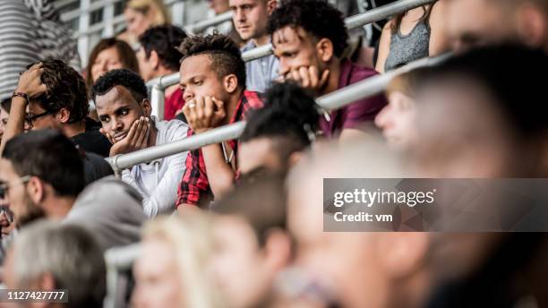 group of friends on a stadium watching a football match - bored audience stock pictures, royalty-free photos & images