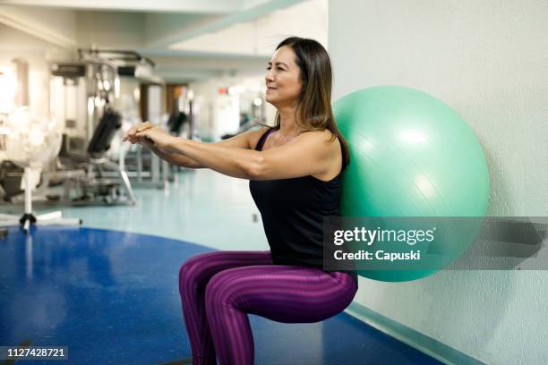 vrouw doen kraken met oefening bal - pilates stockfoto's en -beelden