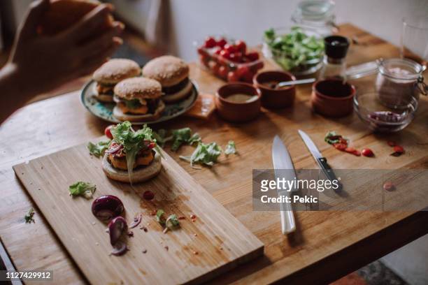 homemade hamburger surrounded with fresh ingredients - arm made of vegetables stock pictures, royalty-free photos & images