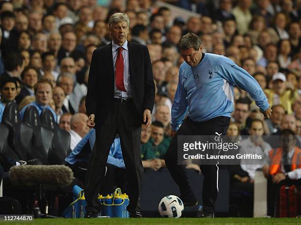 Spurs coach, Clive Allen kicks the match ball as Arsenal manager Arsene Wenger looks on during the Barclays Premier League match between Tottenham...