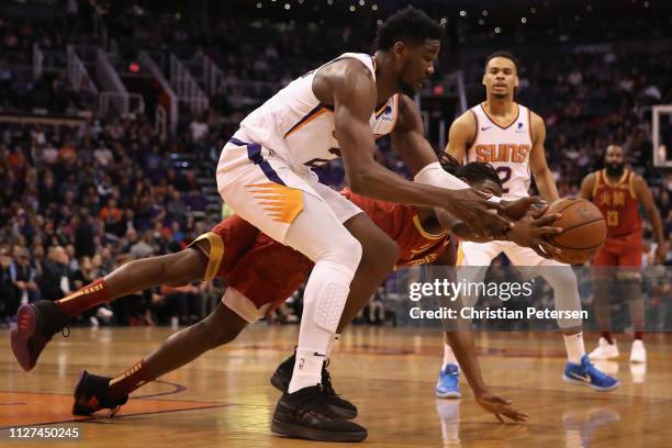 Deandre Ayton of the Phoenix Suns and Kenneth Faried of the Houston Rockets reach for a loose ball during the first half of the NBA game at Talking...