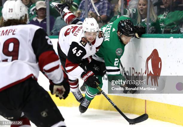 Josh Archibald of the Arizona Coyotes checks Jamie Oleksiak of the Dallas Stars into the boards in the second period at American Airlines Center on...