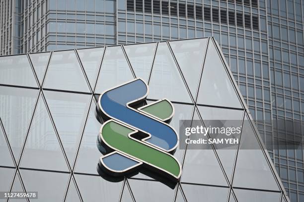 General view shows a logo displayed on a branch of the Standard Chartered Bank in Hong Kong on February 26, 2019. - Standard Chartered's fortunes...