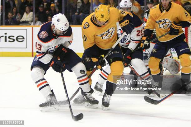 Nashville Predators winger Colton Sissons and Edmonton Oilers right wing Josh Currie battle for the puck during the NHL game between the Nashville...