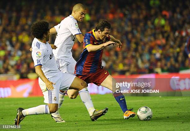 Real Madrid's Brazilian defender Marcelo and Real Madrid's Portuguese defender Pepe vie for the ball with Barcelona's Argentinian forward Lionel...