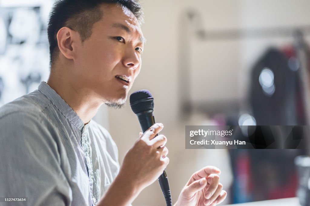 Young businessman is speaking with a microphone