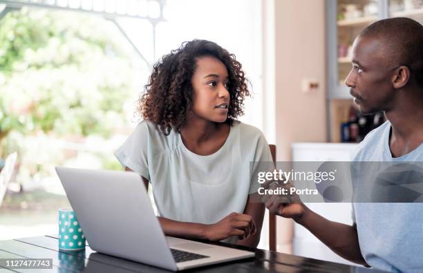 serious young couple communicating at home - woman look straight black shirt stock pictures, royalty-free photos & images