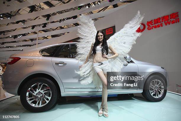 Model poses beside a Great Wall Hover 1F car during the media day of the Shanghai International Automobile Industry Exhibition at Shanghai New...