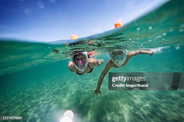 brother and sister swimming underwater in sea - máscara de mergulho imagens e fotografias de stock