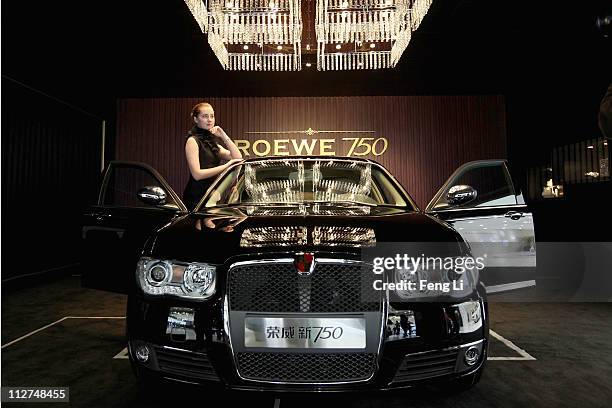 Model poses beside a Roewe 750 car during the media day of the Shanghai International Automobile Industry Exhibition at Shanghai New International...