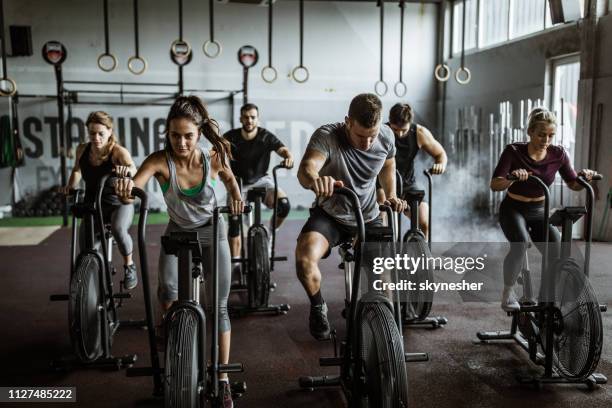 cross fit training op stationaire fietsen! - fitness man gym stockfoto's en -beelden