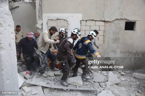 Members of the Syrian Civil Defence carry a wounded person following reported shelling in the town of Khan Sheikhun in the southern countryside of...