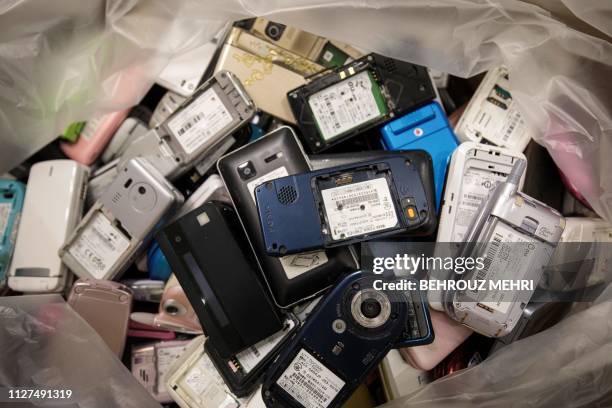 In this picture taken on February 18 a pile of used mobile phones collected by the Tokyo Organising Committee of the Olympic and Paralympic Games is...