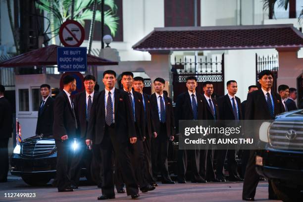 North Korean leader Kim Jong Un's bodyguards surround his car as he leaves after visiting the North Korean embassy in Hanoi on February 26 ahead of...