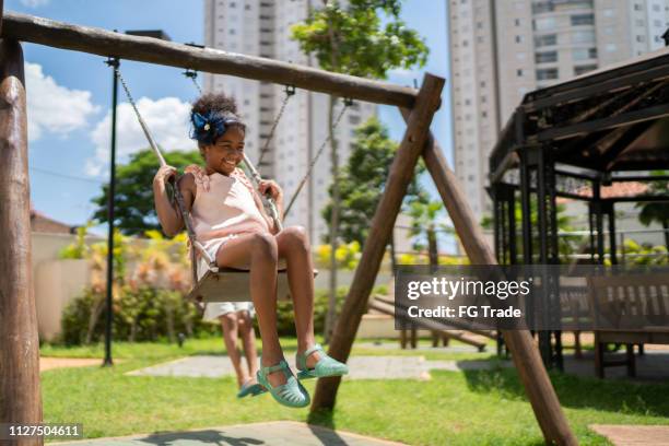 afro latinx children swinging in the playground - using a swing stock pictures, royalty-free photos & images