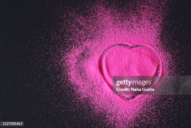 pink powder paint explosion against a black background - heart shape - delhi smog stock pictures, royalty-free photos & images