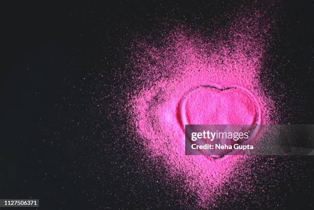 pink powder paint explosion against a black background - heart shape - delhi smog stock pictures, royalty-free photos & images