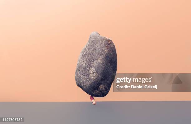 medicin pill under the weight of a stone - västra götalands län stockfoto's en -beelden