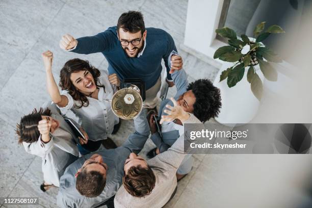 ganhar um troféu para a realização de negócios! - winning - fotografias e filmes do acervo