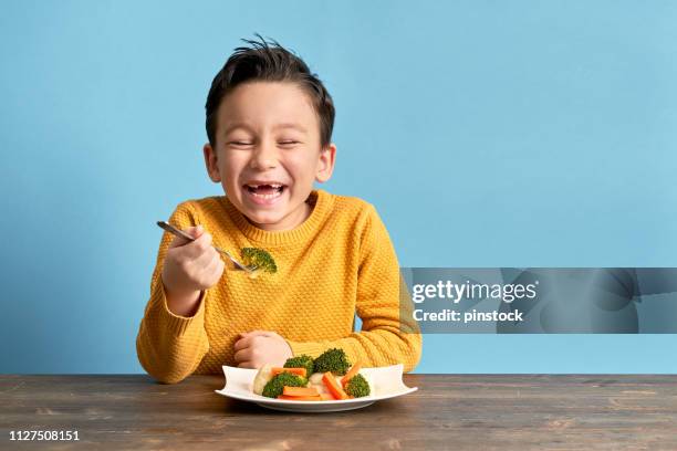 child is eating vegetables. - kids eating imagens e fotografias de stock