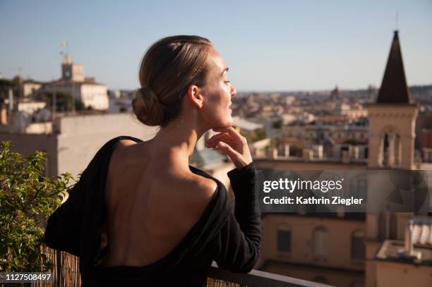 woman enjoying the view from roman rooftop terrace - chignon fotografías e imágenes de stock