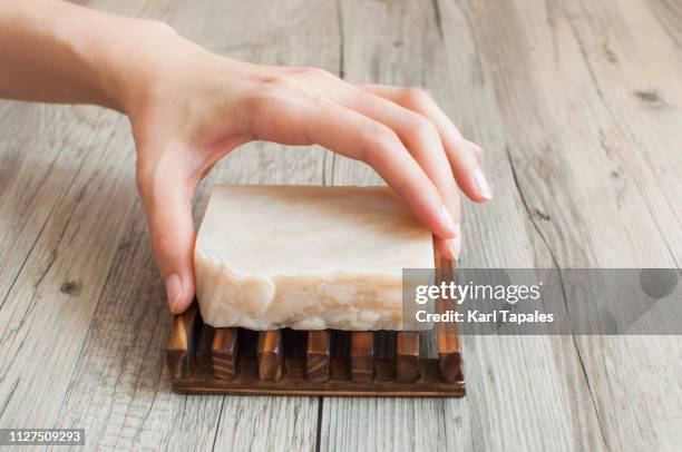 a close-up of a female hand holding a white organic soap - seifenstück stock-fotos und bilder