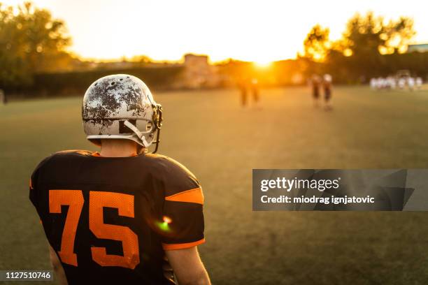 solitary american football player - american football player back stock pictures, royalty-free photos & images
