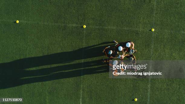 drone point view of players huddling - american football sport stock pictures, royalty-free photos & images