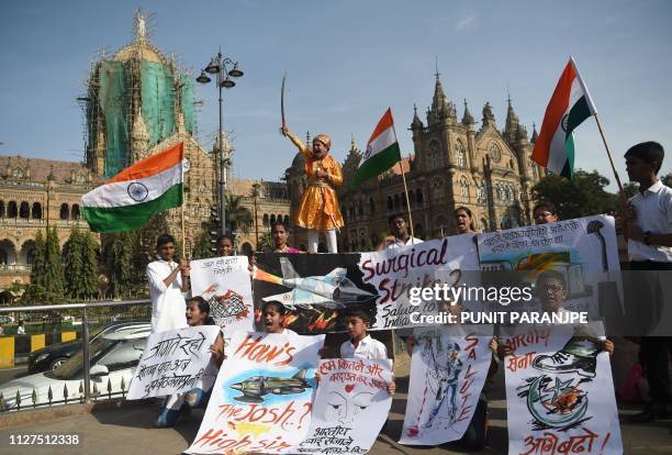 Indians hold placards and national flags as they celebrate the Indian Air Force strike launched on a Jaish-e-Mohammad camp at Balakot, in front of...