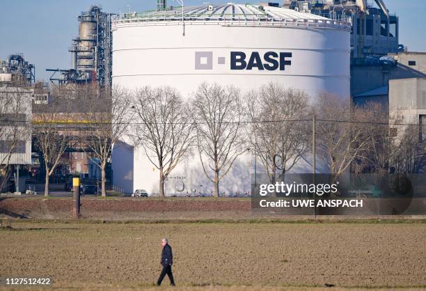 Man walks past tanks of German chemicals giant BASF at the company's headquarters in Ludwigshafen, western Germany, on February 26, 2019. - BASF...