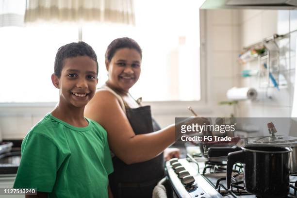 afro latinx mother and son cooking at home portrait - brazilian culture stock pictures, royalty-free photos & images
