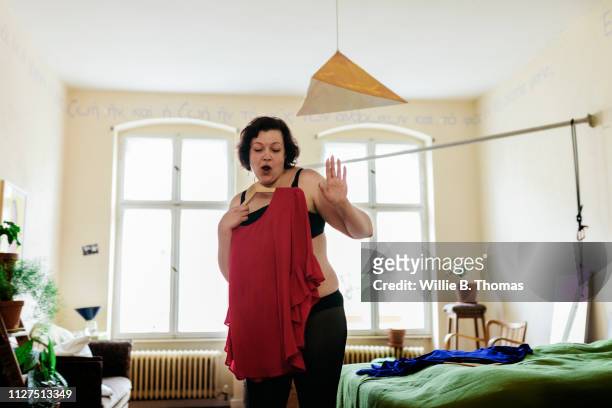 confident woman dancing while getting dressed - getting dressed stockfoto's en -beelden