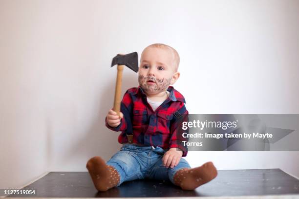 baby boy dressed as a woodcutter and sitting down - opening night of bb forever brigitte bardot the legend stockfoto's en -beelden