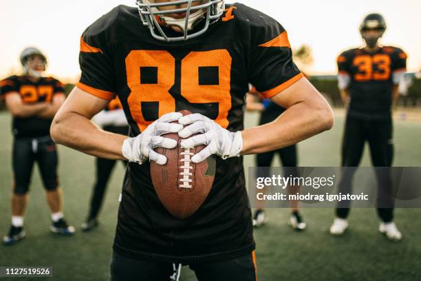 american football player holding ball - jersey fabric stock pictures, royalty-free photos & images