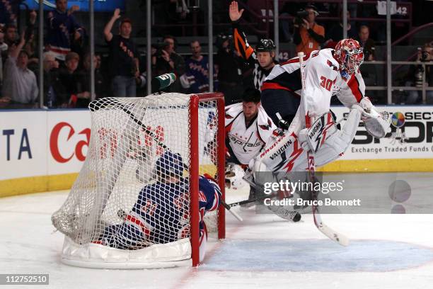 Goalie Michal Neuvirth of the Washington Capitals jumps over Derek Stepan of the New York Rangers as Stepan slides into the net in Game Four of the...