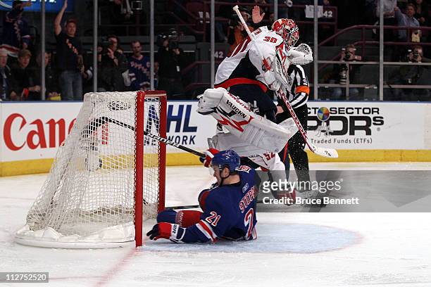 Goalie Michal Neuvirth of the Washington Capitals jumps over Derek Stepan of the New York Rangers as Stepan slides into the net in Game Four of the...