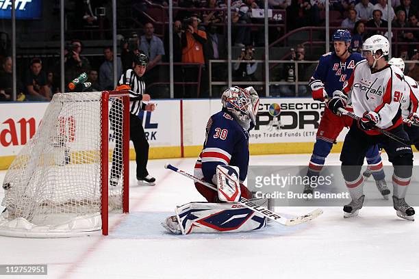 Marcus Johansson of the Washington Capitals scores a goal in the third period to tie the game 3-3 against goalie Henrik Lundqvist of the New York...