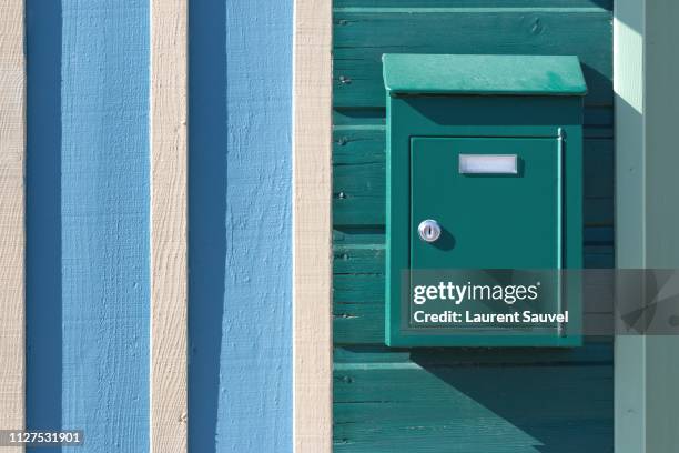 a turquoise mailbox on a turquoise, white and light blue painted wooden wall - mailbox foto e immagini stock