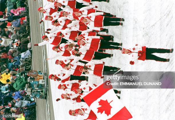 Canadian athletes wave as they parade around the Minami Nagano stadium during the opening ceremony of the 18th Winter Olympics in Nagano 07 February....