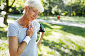 Senior woman with chest pain suffering from heart attack during jogging