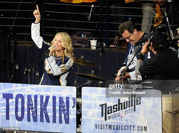 Carrie Underwood performs with Vince Gill during the first intermission of the Nashville Predators and the Anaheim Ducks Game Four of the Western...