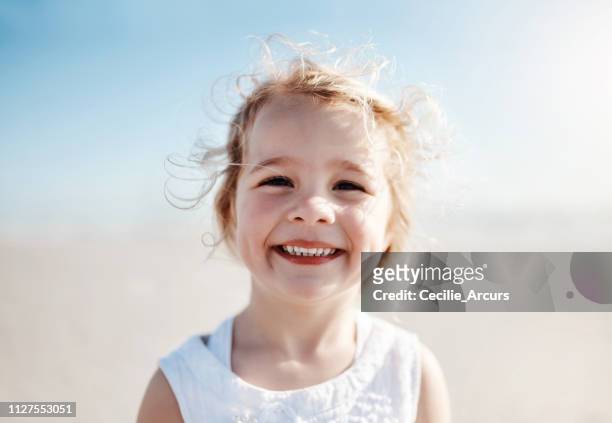 der strand ist nur ein großer sandspielplatz - blonde girl smiling stock-fotos und bilder