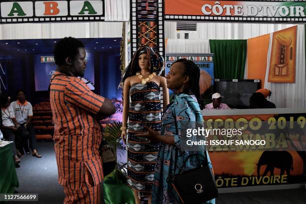 People gesture as they attend the International African Television and Cinema Fair in Ouagadougou on February 26 on the sideline of FESPACO,...