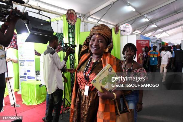 Woman smiles as she attends the International African Television and Cinema Fair in Ouagadougou on February 26 on the sideline of FESPACO, Panafrican...