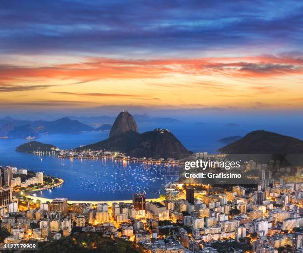 aerial view of rio de janeiro brazil with guanabara bay and sugar loaf at night - copacabana stock pictures, royalty-free photos & images