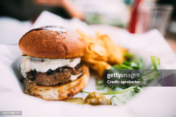 leckere hamburger mit pommes frites auf tisch - cheeseburger and fries stock-fotos und bilder