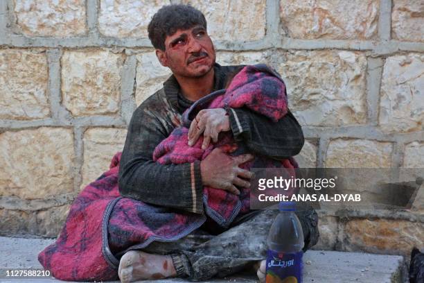 Syrian man weeps as he cradles the body of his daughter who was killed following reported shelling in the town of Khan Sheikhun in the southern...