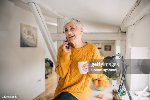 reife frau am telefon - woman using smartphone with laptop stock-fotos und bilder